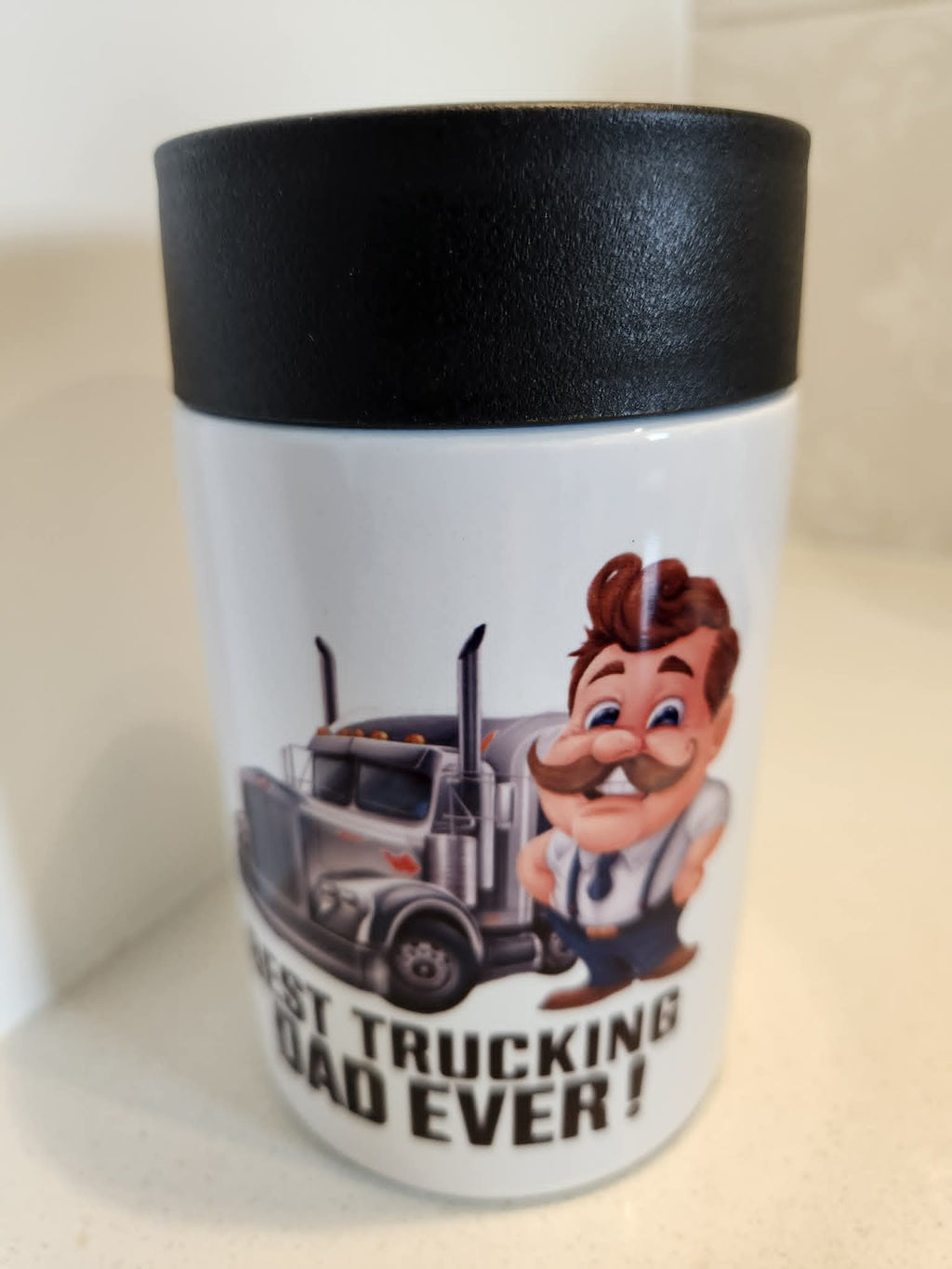 Best Trucking Dad Ever can cooler - front view showing cartoon truckie with moustache leaning on semi-truck