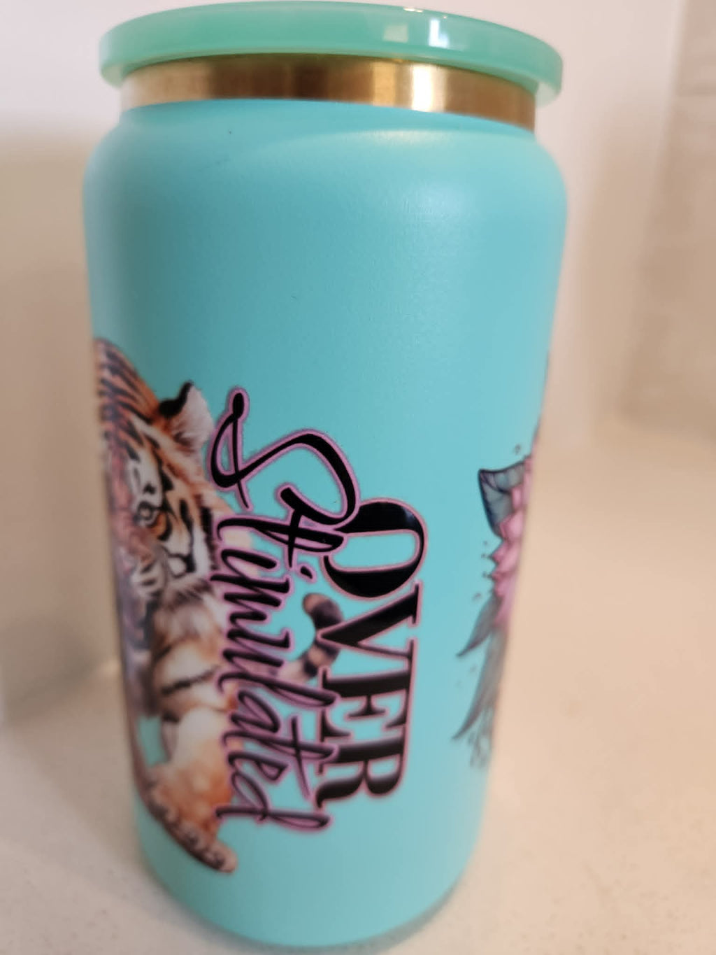 Over Stimulated stainless steel Libby cup - text side showing Over Stimulated script with tiger