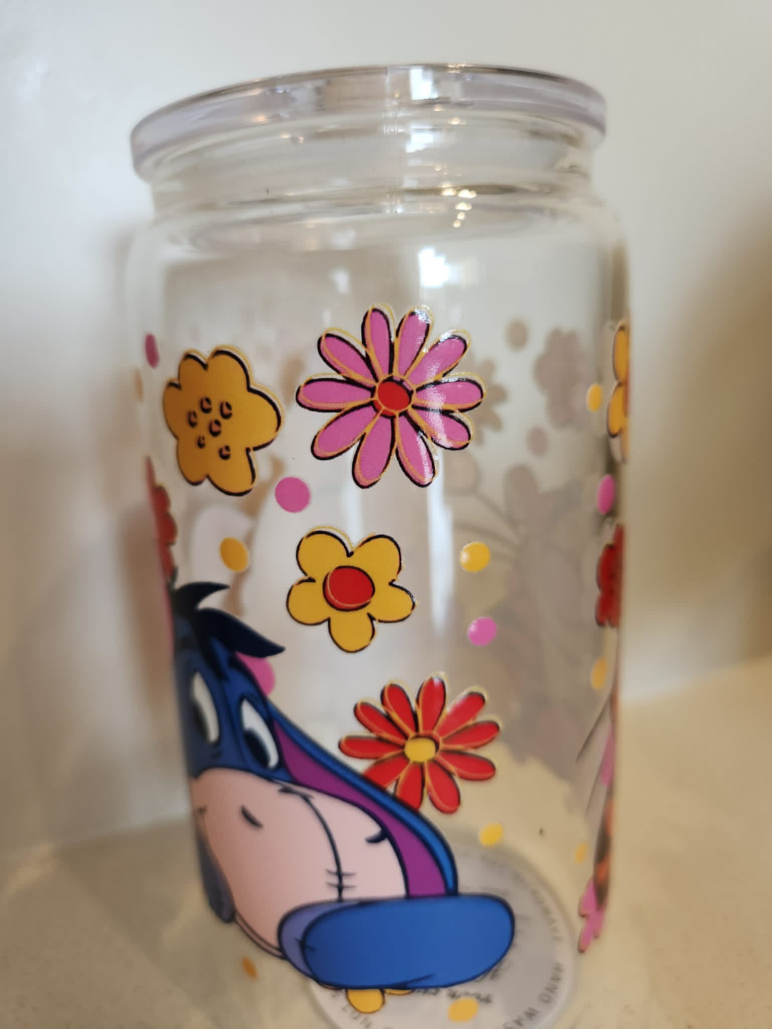 Winnie the Pooh acrylic Libby cup - Eeyore side with colourful retro daisy flowers
