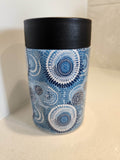 Aboriginal dot art blue can cooler - front view showing intricate concentric circle dot art in navy and white on blue