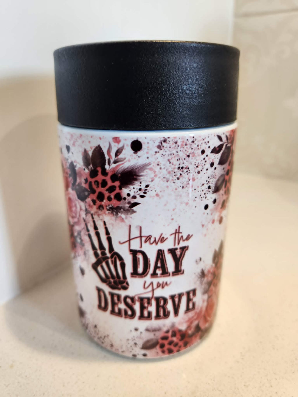 Have The Day You Deserve can cooler - front view showing skeleton hand peace sign with pink roses and Have The Day You Deserve text